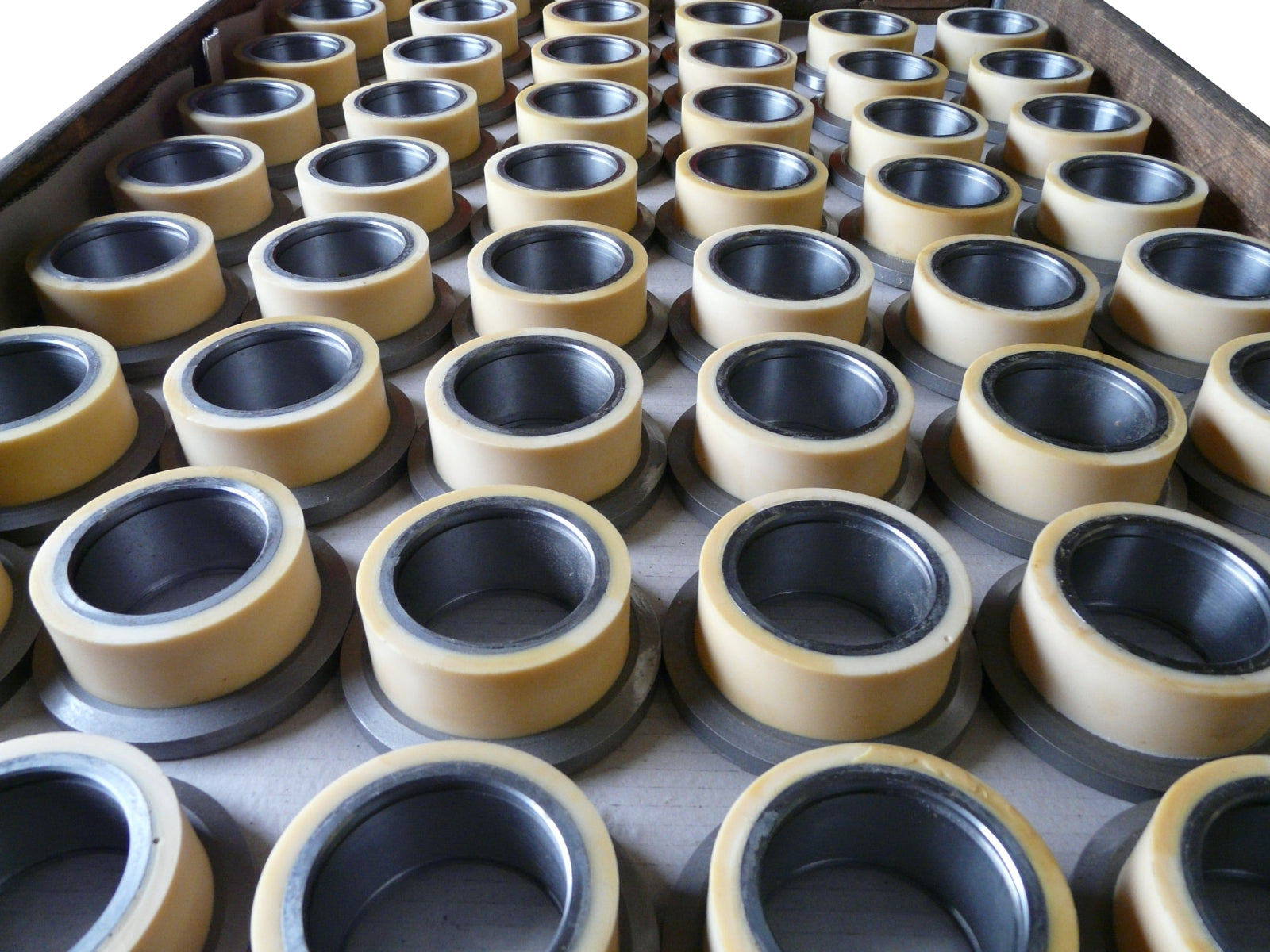 Viele Profilrollen aus Stahl mit Vulkollan-Lauffläche, nachträglich beschichtet, flach  in einer Palette gelagert